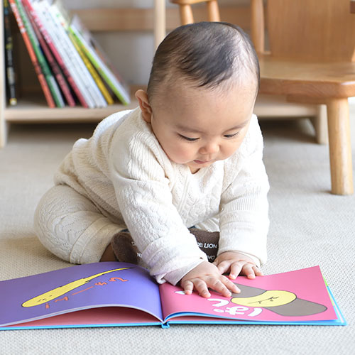 0歳の赤ちゃんが絵本を読んでいる