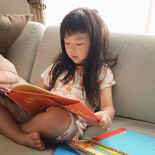 4歳の子どもが絵本を読んでいる